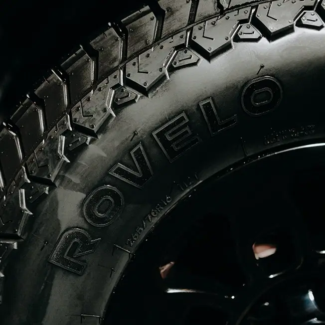 Rovelo tire sidewall showing aggressive all-terrain tread on black wheel