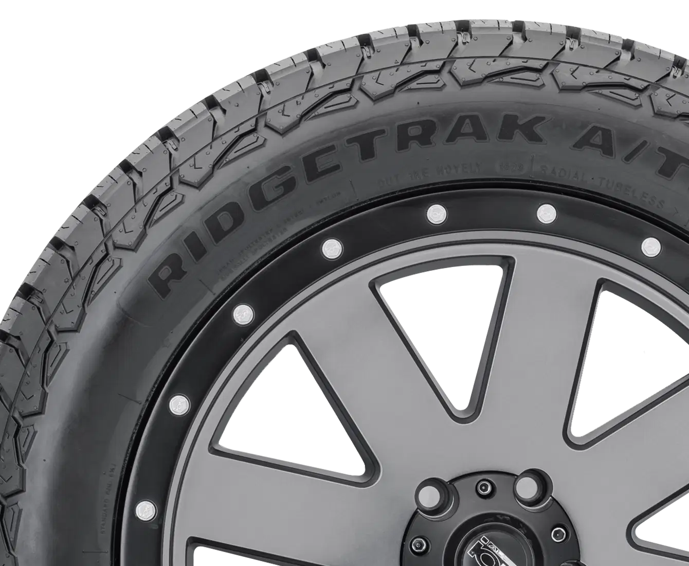 Close-up of Ridgestone Ridgtrak A/T tire showcasing rugged tread design and stylish wheel rim for all terrain vehicles.