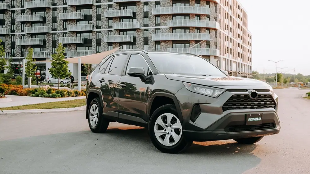 Sleek SUV parked in urban setting, showcasing ROVelo tires designed for all season performance.