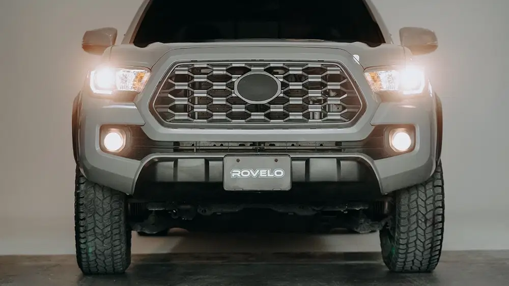 Front view of a gray SUV equipped with all terrain tires, showcasing the Rovelo logo on the license plate.